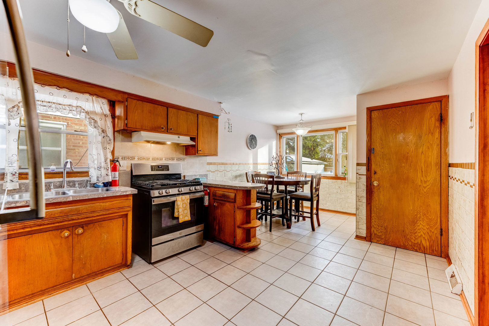 2117 West 71st Place Chicago, IL 60636 - Photo 11 of 31 a kitchen with stainless steel appliances granite countertop a stove top oven a sink a dining table and chairs