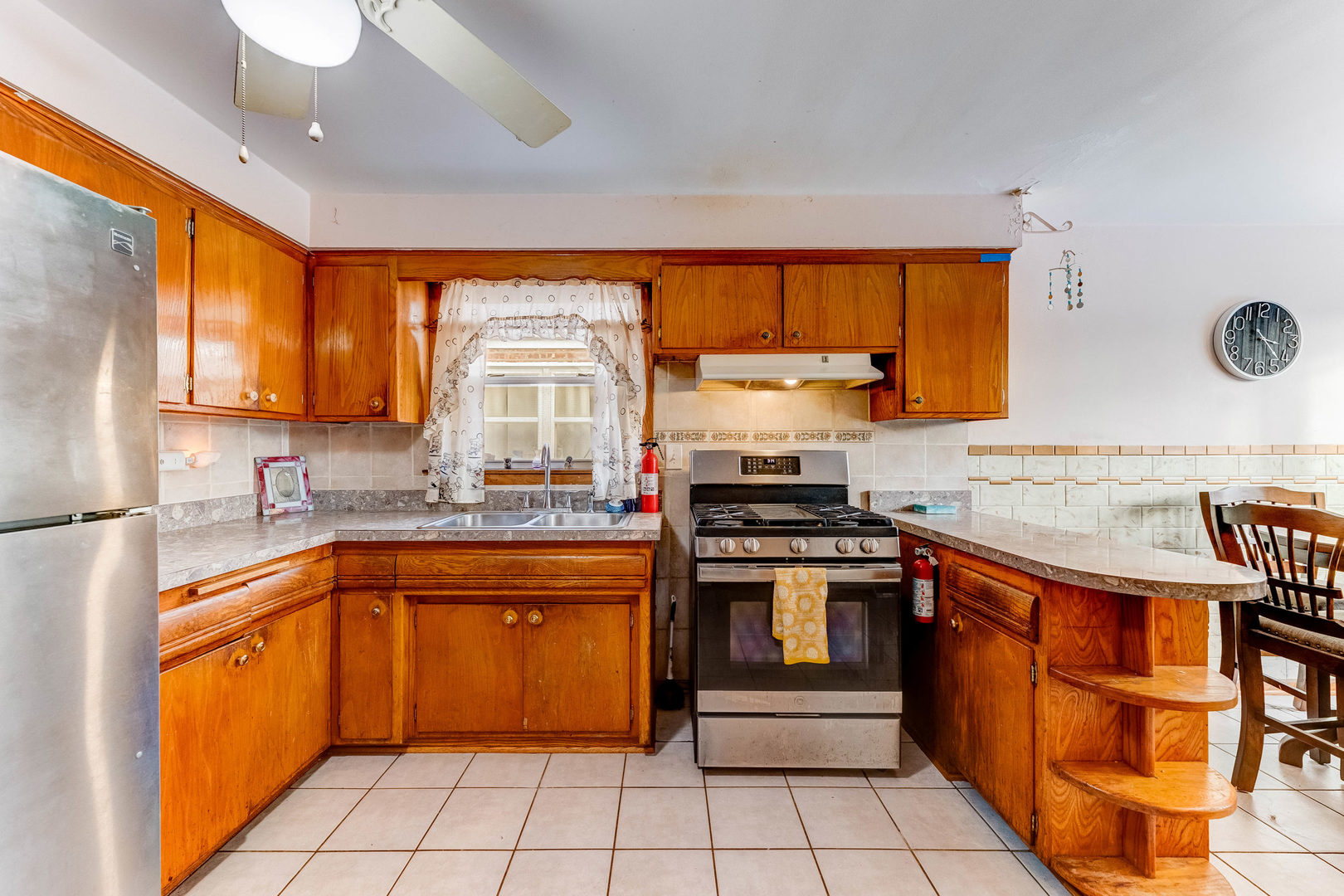 2117 West 71st Place Chicago, IL 60636 - Photo 12 of 31 a kitchen with stainless steel appliances a stove sink and cabinets