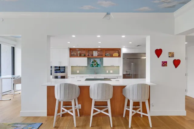 a dining room with furniture a rug and a floor to ceiling window