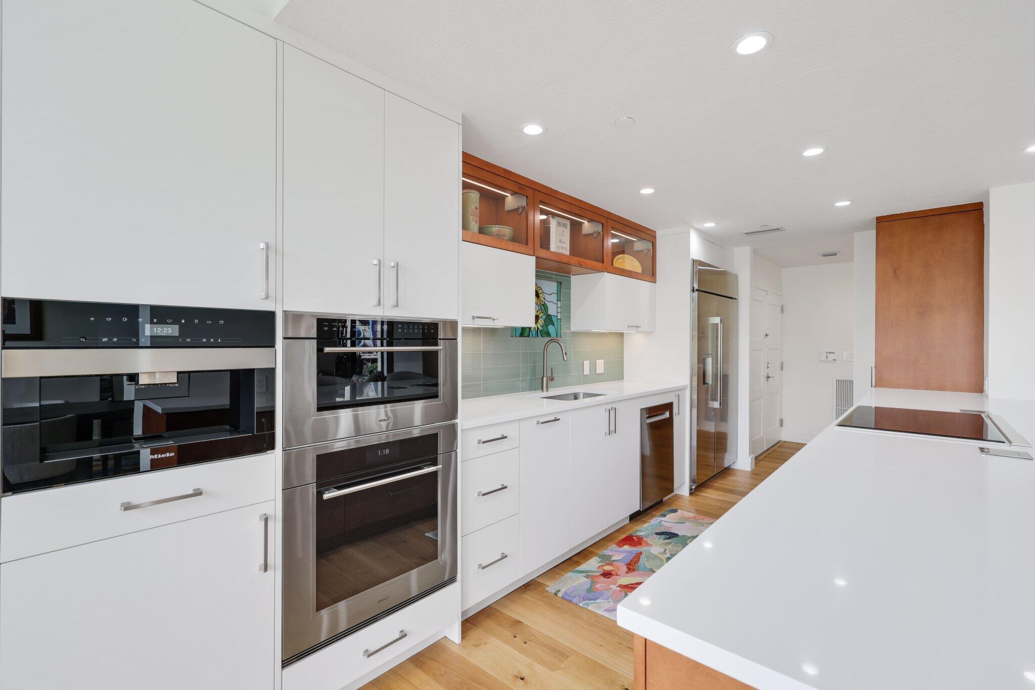 3900 North Ocean Boulevard, Unit LANAI Delray Beach, FL 33483 - Photo 13 of 40 a kitchen with white cabinets and white appliances