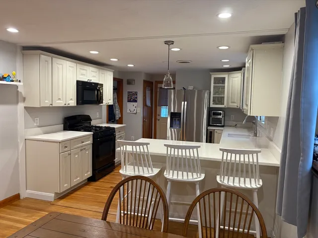 a kitchen with a dining table chairs and refrigerator