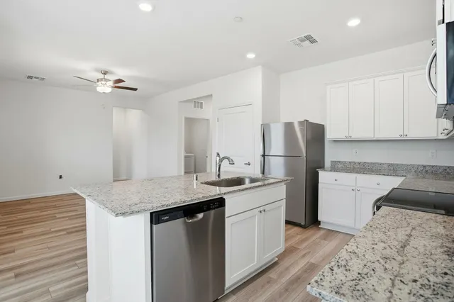 a kitchen with a sink appliances and cabinets