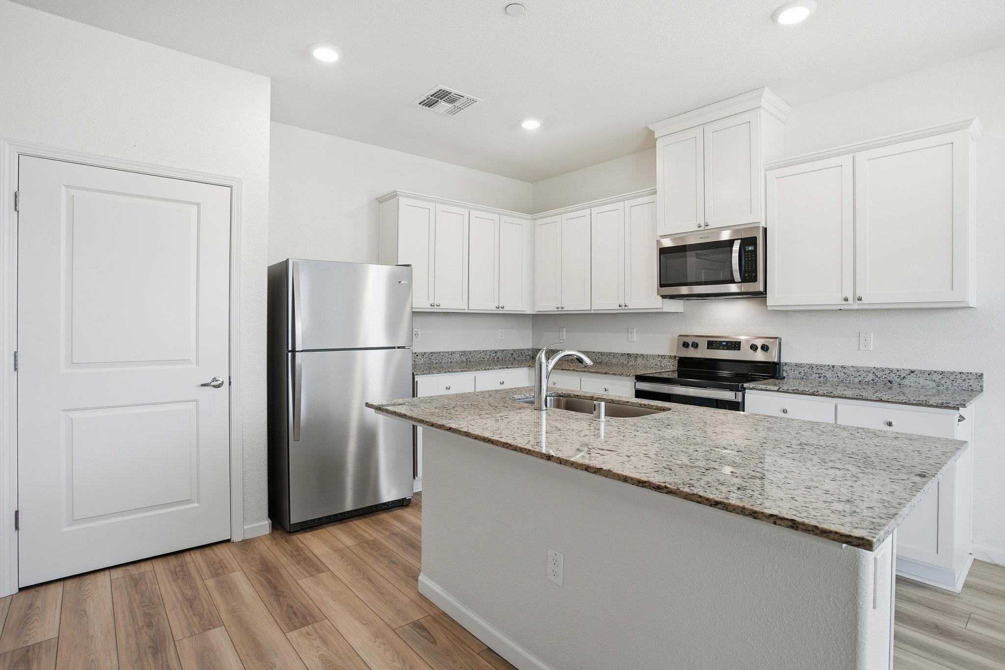 2055 Stars Drive Rio Vista, CA 94571 - Photo 9 of 43 a kitchen with granite countertop a refrigerator a sink a stove a microwave and cabinets