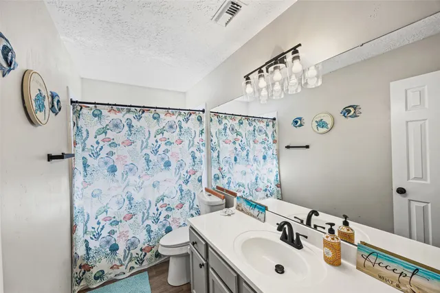 a bathroom with a sink and mirror with toilet