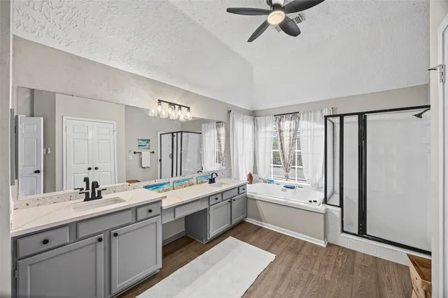 a large white bathroom with a double vanity sink a mirror and a bathtub