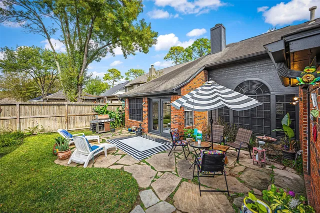 a view of a patio with table and chairs potted plants and a large tree