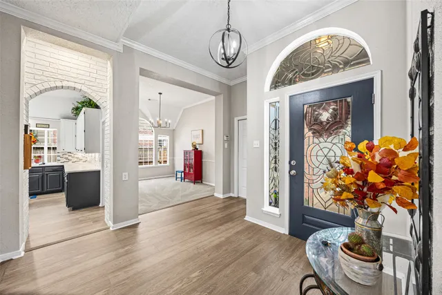 a view of a hallway with furniture and a chandelier