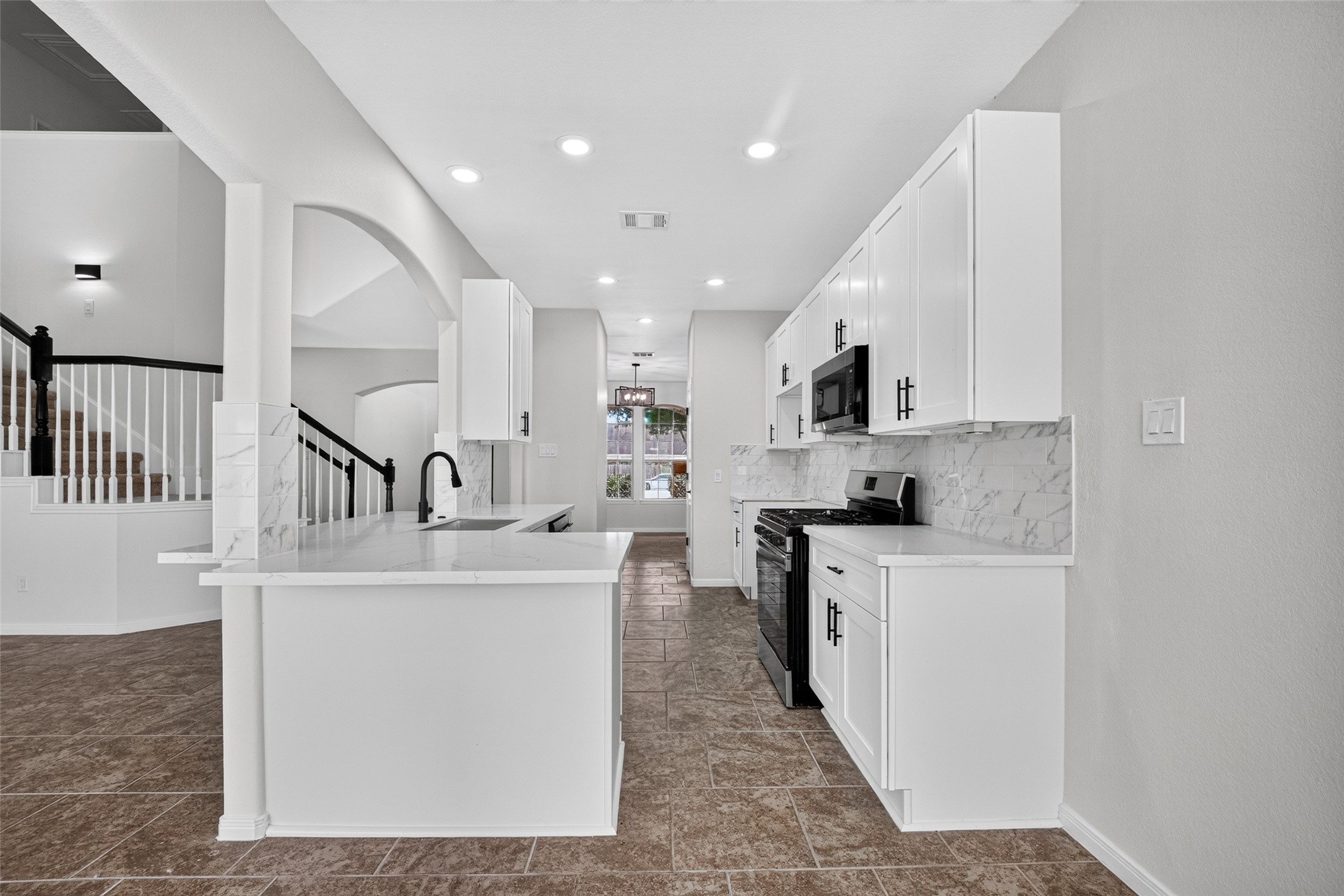 22623 Ebbets Field Drive Spring, TX 77389 - Photo 14 of 43 Designed for both the everyday cook and the effortless host, this chef-inspired kitchen centers around crisp white cabinetry and pristine marble countertops. Premium stainless steel appliances complete the look, while the open-concept layout flows smoothly onto stylish tile floors—keeping you connected to the conversation in the living room no matter what’s on the menu.