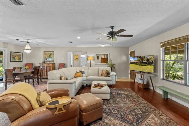 a living room with furniture a ceiling fan and a rug