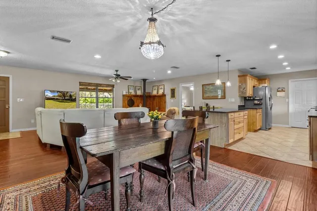 a kitchen with stainless steel appliances granite countertop wooden floor stove top oven and refrigerator