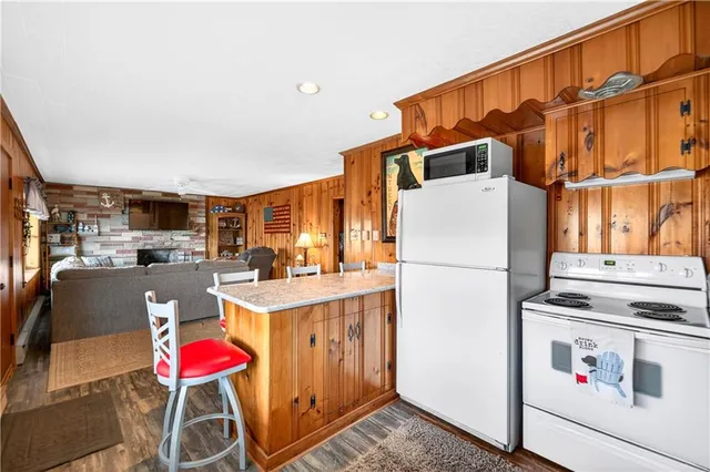a room with stainless steel appliances kitchen island granite countertop a sink and cabinets