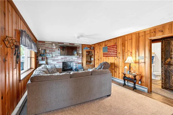 a living room with furniture a flat screen tv and a floor to ceiling window