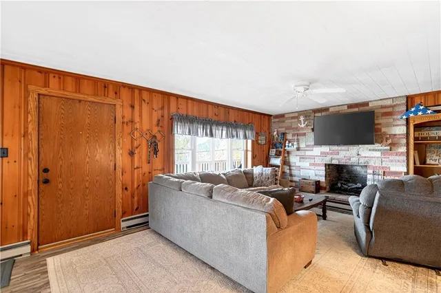 a living room with furniture a fireplace and a large window