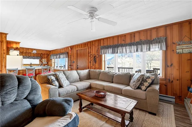 a living room with furniture a ceiling fan and a window