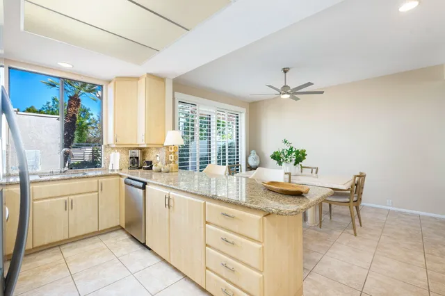 a kitchen with kitchen island granite countertop a sink a counter top space and cabinets