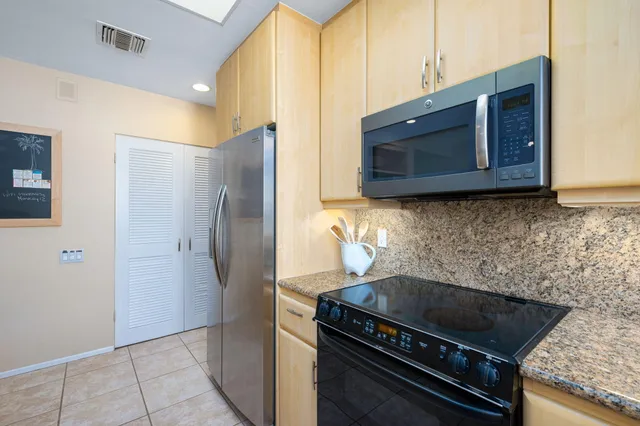 a kitchen with stainless steel appliances granite countertop a refrigerator and a sink