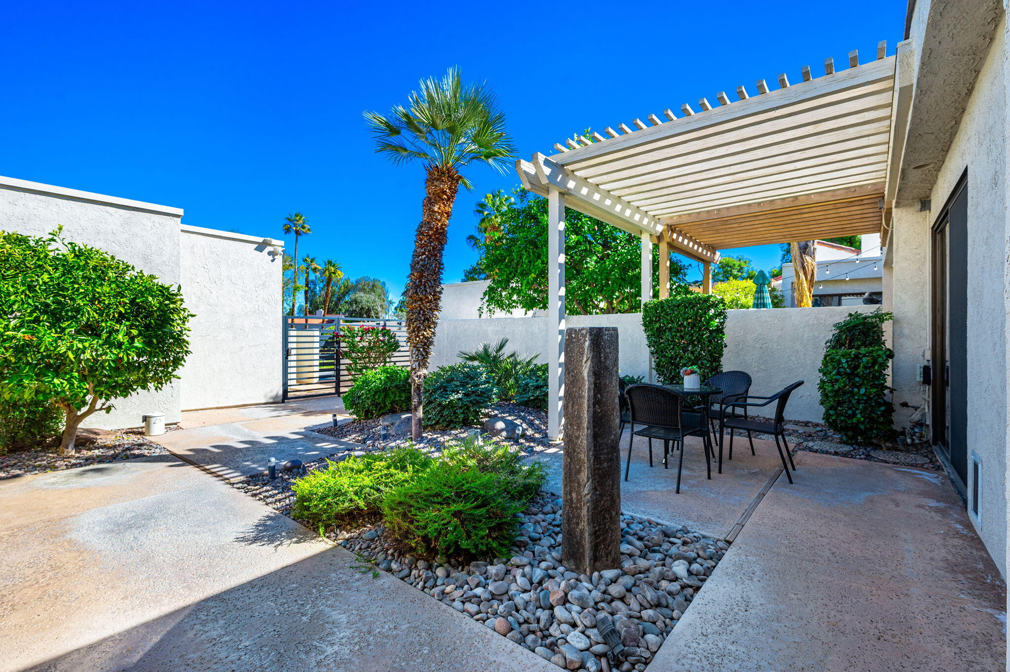 717 Inverness Drive Rancho Mirage, CA 92270 - Photo 37 of 46 a view of a patio with table and chairs potted plants