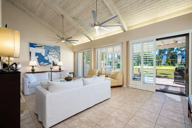 a living room with furniture a flat screen tv and a large window