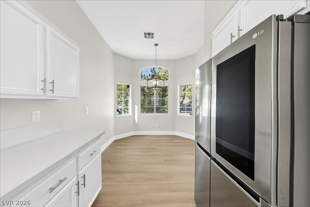1906 Cardinal Point Street Henderson, NV 89012 - Photo 5 of 20 Sunlight streams through arched windows into a bright dining nook with light wood flooring.