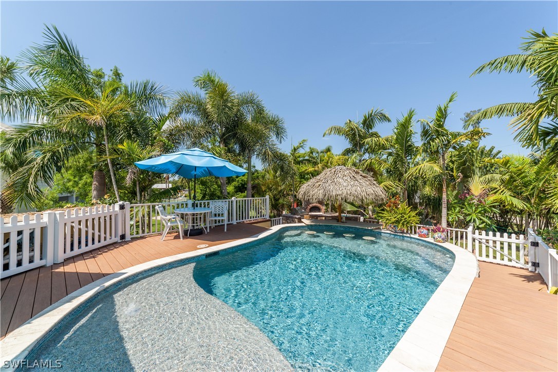 7146 Congdon Road Fort Myers, FL 33908 - Photo 22 of 50 a swimming pool with table and chairs under an umbrella