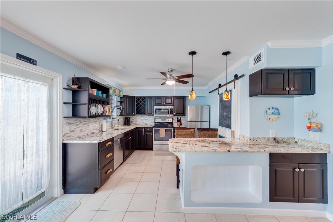 7146 Congdon Road Fort Myers, FL 33908 - Photo 26 of 50 a kitchen with stainless steel appliances kitchen island granite countertop a sink and cabinets