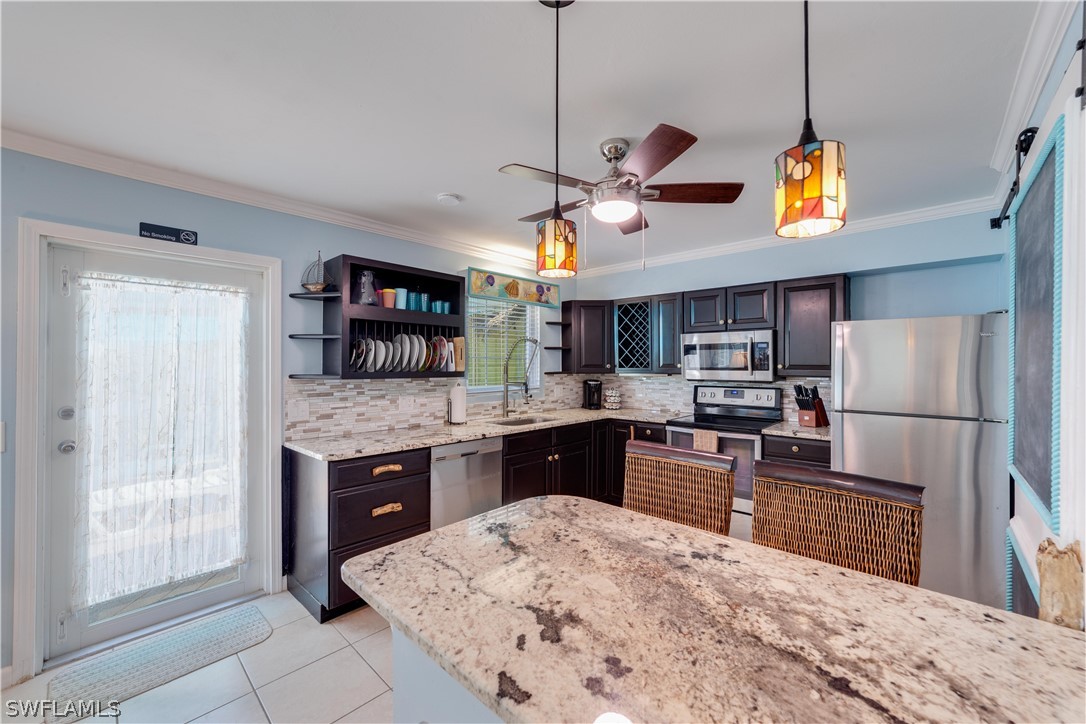 7146 Congdon Road Fort Myers, FL 33908 - Photo 28 of 50 a kitchen with stainless steel appliances granite countertop a sink a stove a refrigerator cabinets and wooden floor