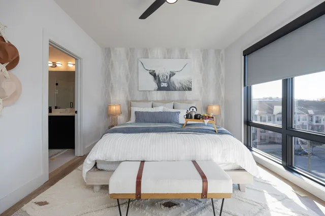 a bedroom with furniture and a large window