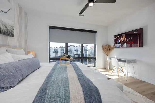 a living room with furniture large window and a flat screen tv