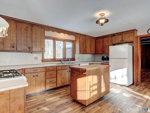 a kitchen with a refrigerator a stove a sink and a window