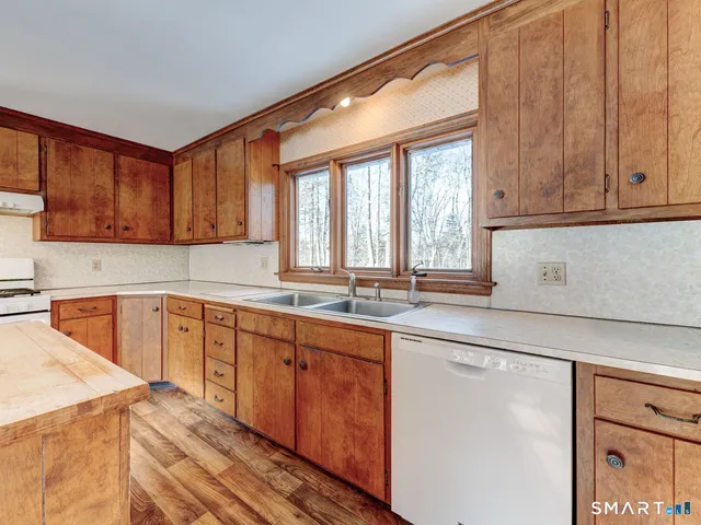a kitchen with stainless steel appliances granite countertop a sink and cabinets with wooden floor