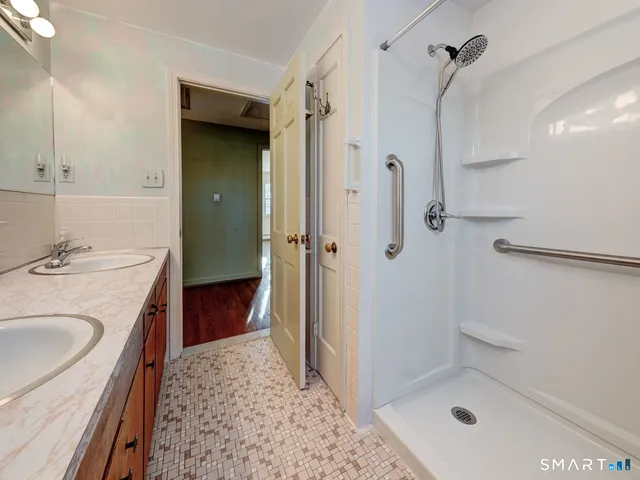 a bathroom with a granite countertop sink a toilet a mirror and a window