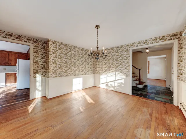 a view of a living room with a large window and wooden floor
