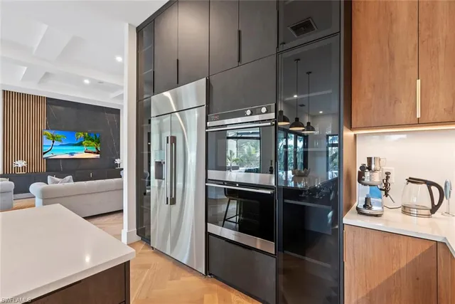 a kitchen with stainless steel appliances kitchen island granite countertop a refrigerator and a sink
