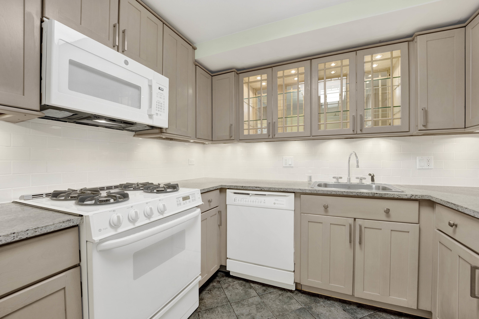 931 West Winona Street, Unit GDN Chicago, IL 60640 - Photo 12 of 18 a kitchen with granite countertop white cabinets and white appliances
