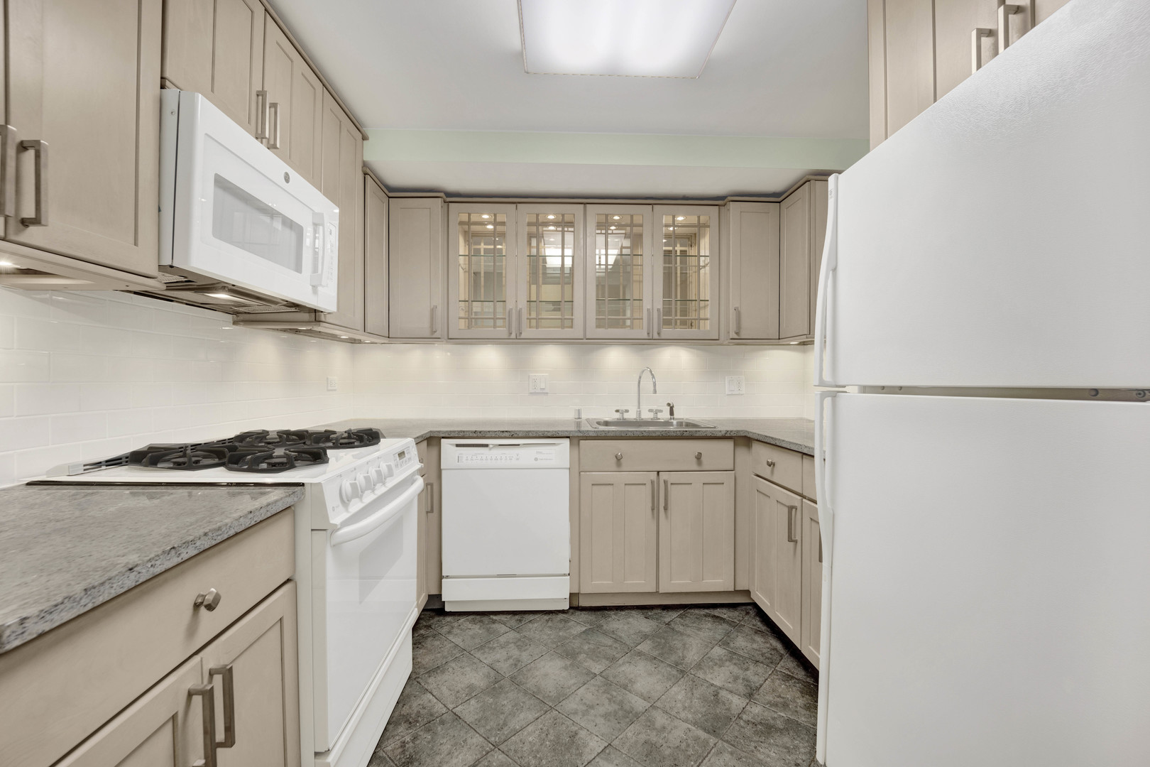 931 West Winona Street, Unit GDN Chicago, IL 60640 - Photo 13 of 18 a kitchen with granite countertop white cabinets and white appliances