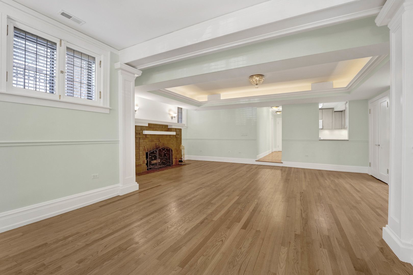 931 West Winona Street, Unit GDN Chicago, IL 60640 - Photo 4 of 18 an empty room with wooden floor fireplace and windows