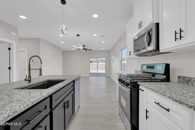 a kitchen with granite countertop a sink and stove