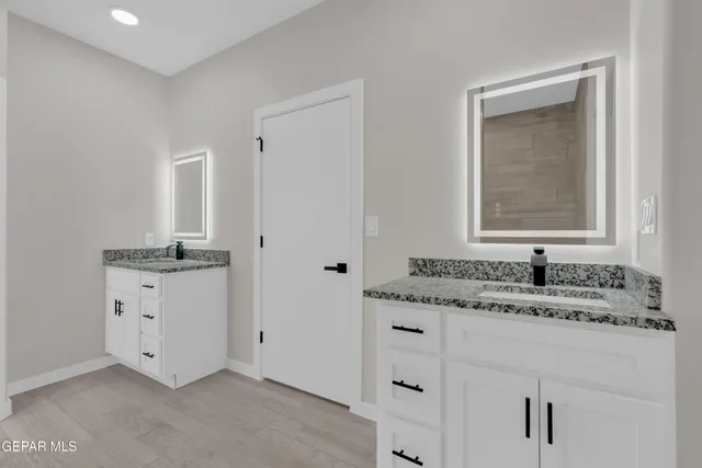 a bathroom with a granite countertop sink and a mirror