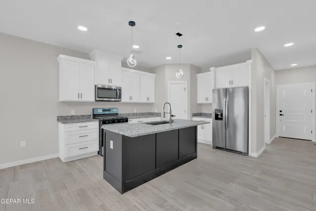a kitchen with white cabinets and stainless steel appliances