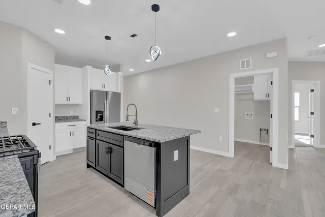 a kitchen with stainless steel appliances granite countertop a stove and a refrigerator