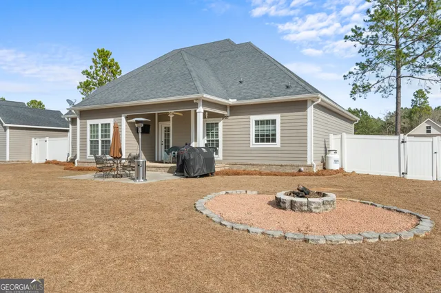 a view of a house with backyard and sitting area
