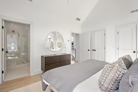 a bedroom with a bed a mirror and shower