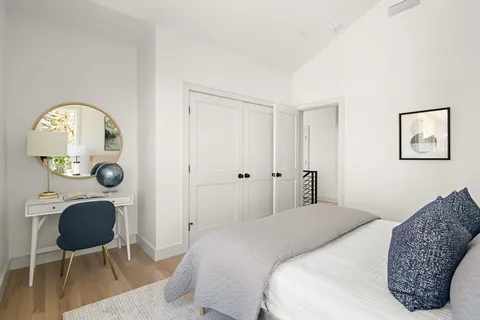 a bedroom with a bed a dresser and chair