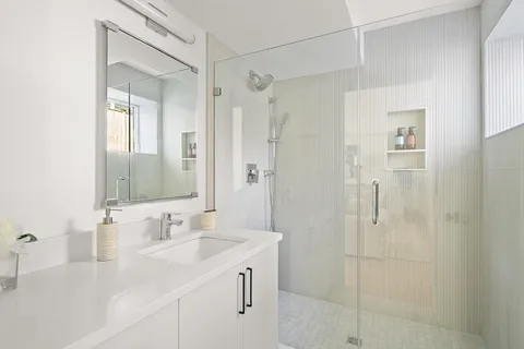 a bathroom with a shower sink vanity granite and shower