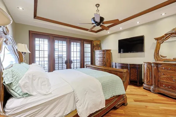 a bedroom with a bed and dresser with mirror