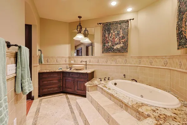 a spacious bathroom with a tub sink and mirror
