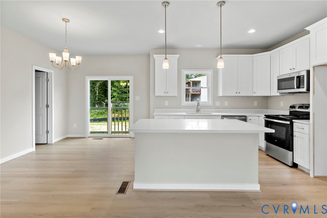 8201 Excaliber Place North Chesterfield, VA 23237 - Photo 2 of 12 a large kitchen with granite countertop a stove a sink a center island and wooden floor