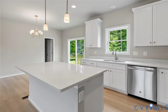 a kitchen with kitchen island granite countertop a sink a counter top space and living room view