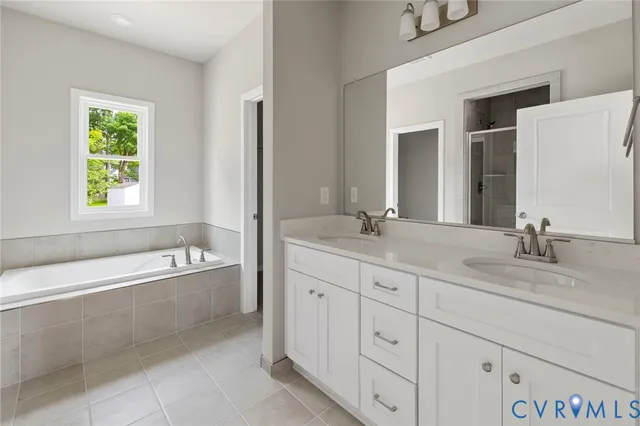 a bathroom with a granite countertop tub sink and mirror