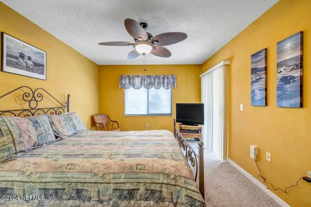 a bedroom with a bed and a painting on the wall